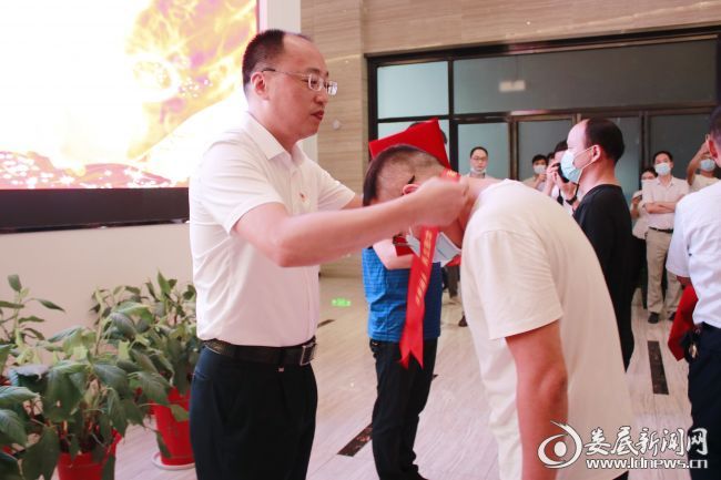 (市退役军人事务局党组书记、局长吴润民为退役军人代表佩戴“光荣退役、再立新功”绶带)