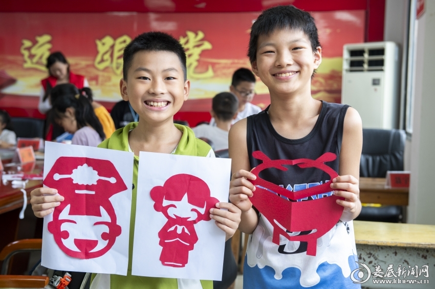 7月27日,孩子们展示自己的剪纸作品。