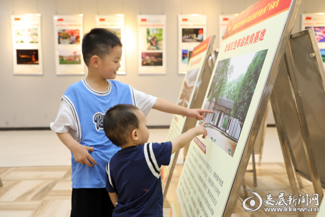 (对图展很感兴趣的两位小朋友)