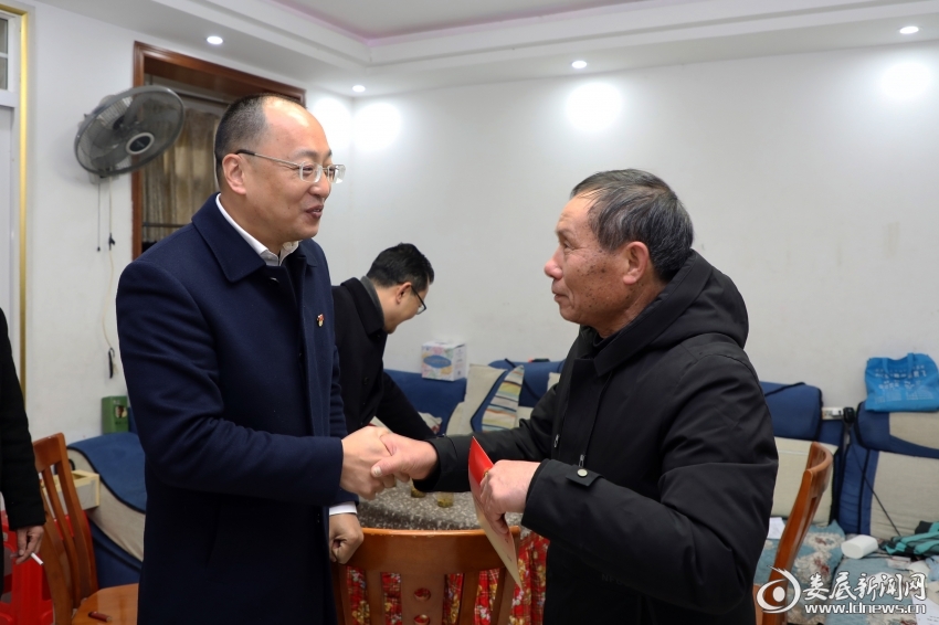 （娄底市退役军人事务局党组书记、局长吴润民与慰问对象沟通交谈，并送上慰问金）