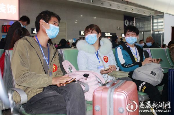 （返岗农民工在候车室与同伴聊天）